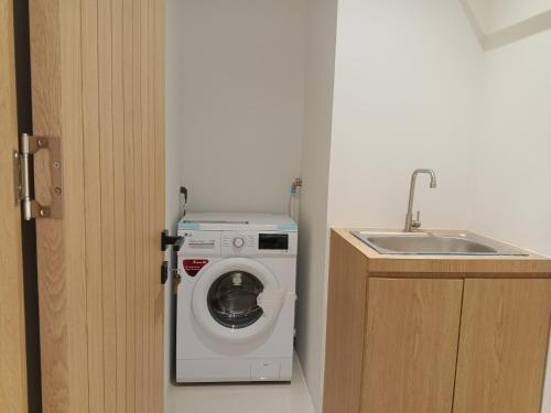 a washing machine in a bathroom next to a sink at Formosa Spacious Apartments with Netflix & Pick Up Service by MESA in Nagoya