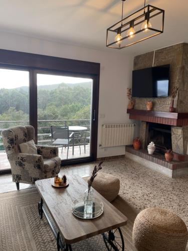 a living room with a fireplace and a table and chairs at Balcón da Ría 