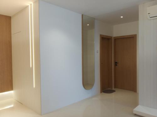 a white hallway with a mirror and a door at Formosa Spacious Apartments with Netflix & Pick Up Service by MESA in Nagoya