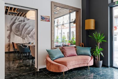 sala de estar con sofá rosa y espejo en Onyx Luxury Budapest, en Budapest