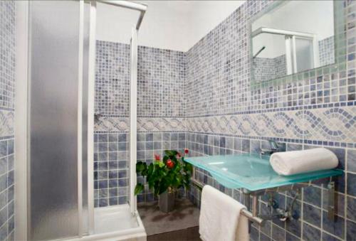 y baño de azulejos azules con lavabo y ducha. en 5-bed apartment in the heart of the city en Barcelona