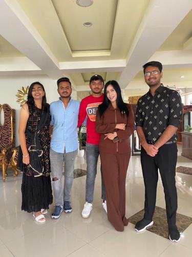 a group of people posing for a picture in a room at Votel Hotel De'Pratnya Kediri in Kediri