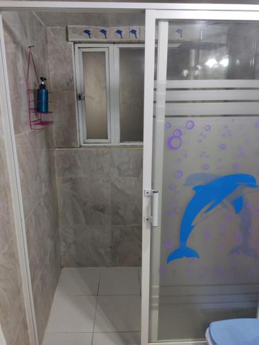 łazienka z prysznicem z niebieskim delfinem na drzwiach w obiekcie Flatshare Department w Baños