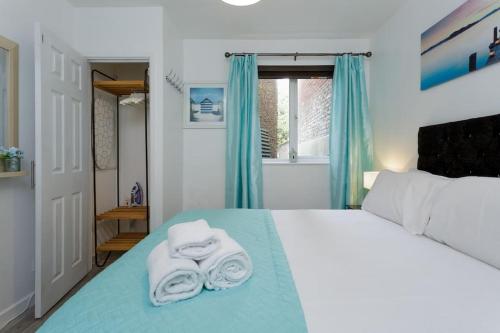 a bedroom with a bed with towels on it at Eastney Escape in Portsmouth