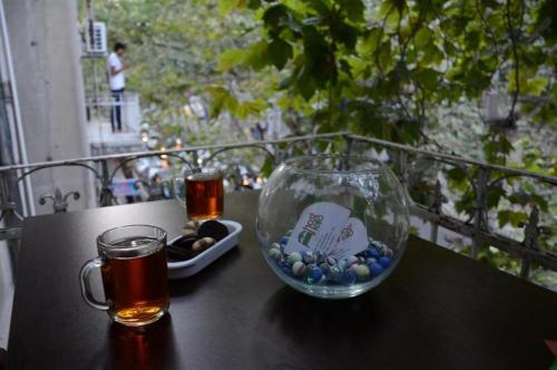 a glass vase sitting on a table with a drink at Hostello in Baku