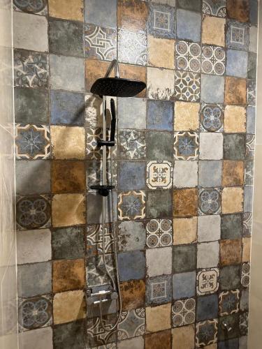 a shower in a bathroom with a tiled wall at appartement à oujda in Oujda