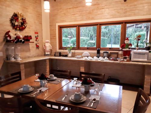 a dining room with a table and a kitchen at Pousada Bucaneve in Monte Verde