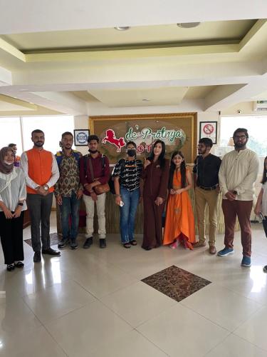a group of people posing for a picture in a lobby at Votel Hotel De'Pratnya Kediri in Kediri
