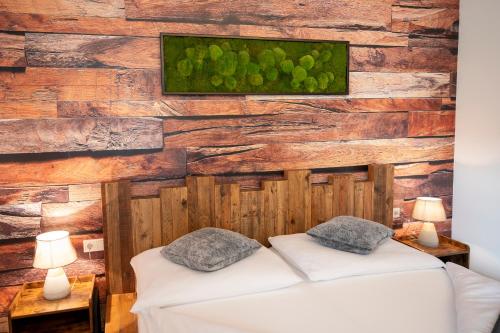 2 łóżka w pokoju z drewnianą ścianą w obiekcie Berg&Selig Apartment w mieście Pfarrwerfen