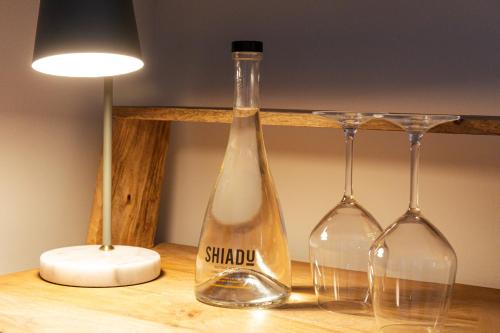 a bottle and two wine glasses on a table at Casa Alhaja by Shiadu in Seville