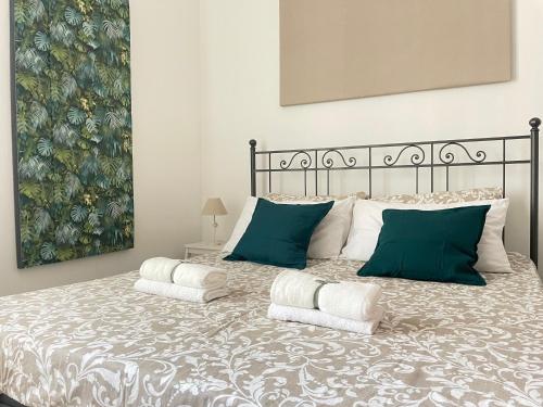 Volupta’s house Trastevere في روما: غرفة نوم بسرير كبير ومخدات خضراء وبيضاء