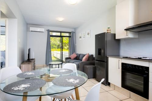 a kitchen and living room with a table and chairs at Lux Garden Ballito Groves 1101 in Ballito