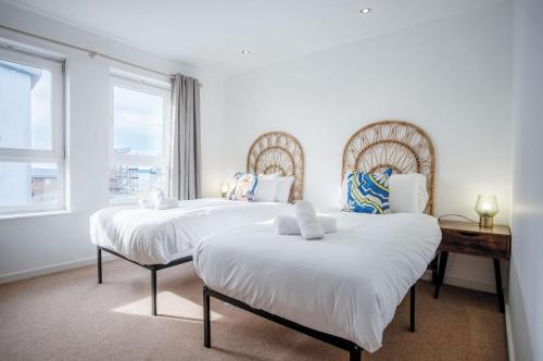 2 bedden in een witte kamer met een raam bij The Penthouse - 3 Bedroom Apartment - Llanelli in Llanelli