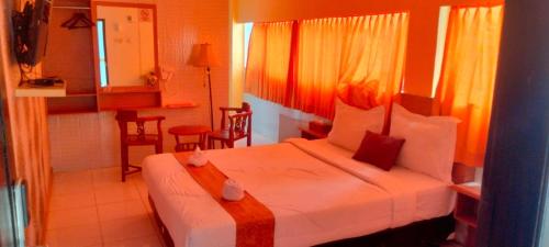a hotel room with a bed and a kitchen at Votel Hotel De'Pratnya Kediri in Kediri
