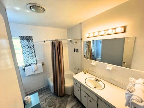 een badkamer met een wastafel, een toilet en een spiegel bij Conch Key Fishing Lodge & Marina in Conch Key
