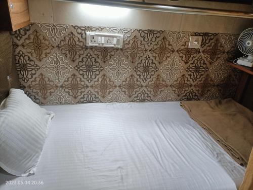 uma cama branca num quarto com uma parede em Metro inn dormitory em Mumbai