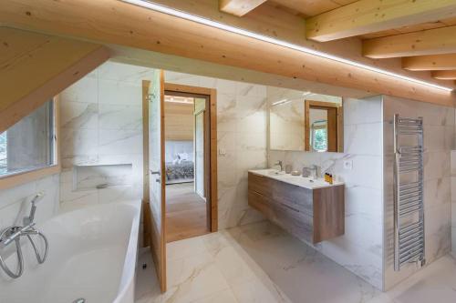 シャテルにあるBlack Diamond - Chalet - BO Immobilier- remises sur les forfaits de skis Châtel ou Portes du soleilの浴槽、シャワー、洗面台を備えたバスルーム