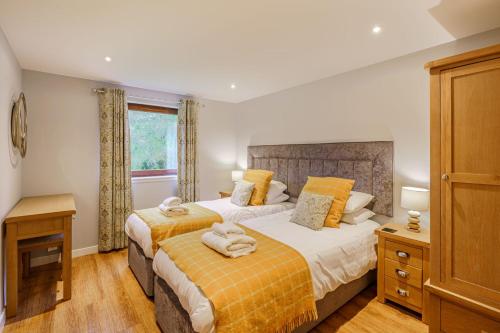 a bedroom with two beds and a window at Lord Galloway 36 with Hot Tub in Newton Stewart