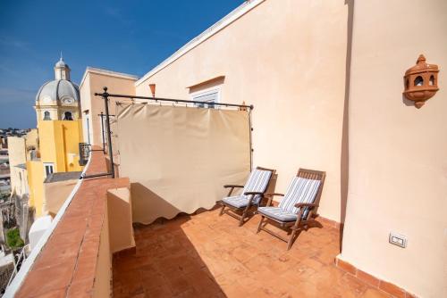 a balcony with two chairs on a building at Hotel La Casa sul Mare in Procida