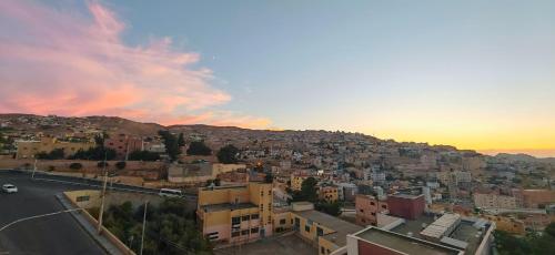 a view of a city with the sunset in the background at Cleopetra Hotel in Wadi Musa