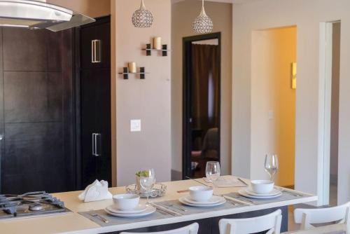 a dining room table with plates and wine glasses at Casa Todos Santos with Gated Parking at Casas Sanblu in Ensenada