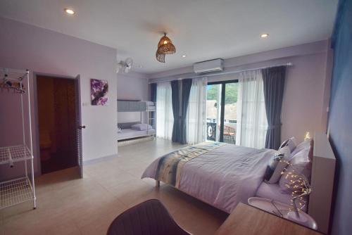 a bedroom with a bed and a large window at Neverland Hua Hin - Beach Retreat Home in Hua Hin