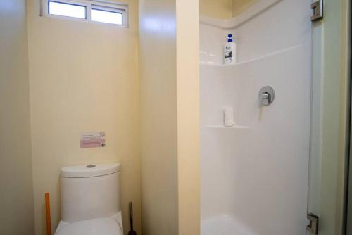 a bathroom with a toilet and a shower and a window at Casa Solmar with Gated Parking at Casas Sanblu in Ensenada