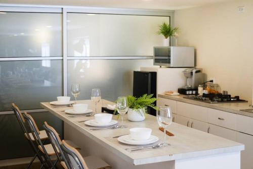 a kitchen with a table with wine glasses on it at Casa San Miguel with Gated Parking at Casas Sanblu in Ensenada
