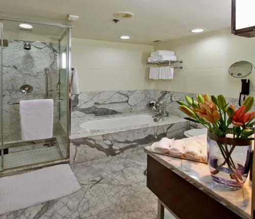 a bathroom with a shower and a tub and a sink at ITC Windsor, a Luxury Collection Hotel, Bengaluru in Bangalore