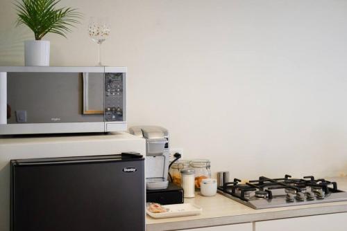 a kitchen with a microwave and a stove top oven at Casa San Miguel with Gated Parking at Casas Sanblu in Ensenada