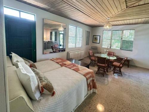 a bedroom with a large bed and a dining room at KASA Finca La Limonada near Palmas Del Mar in Humacao