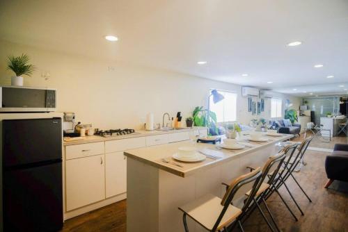 a kitchen with a long island with chairs and a counter at Casa San Miguel with Gated Parking at Casas Sanblu in Ensenada