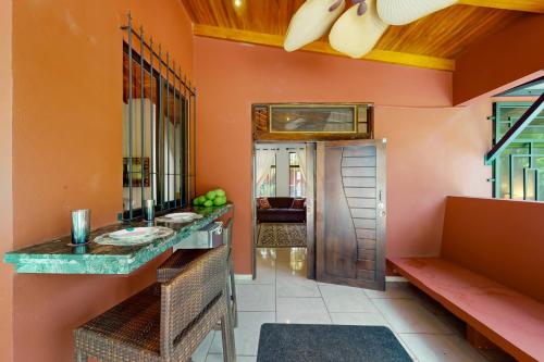 uma casa de banho com paredes cor-de-laranja, um lavatório e um espelho. em Casa Las Lajas em Esterillos