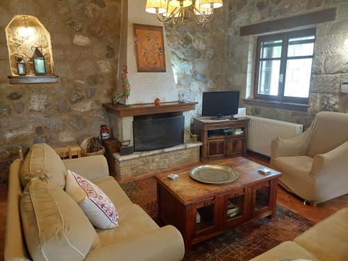 ein Wohnzimmer mit 2 Sofas und einem TV in der Unterkunft Lilea Country House in Lílaia
