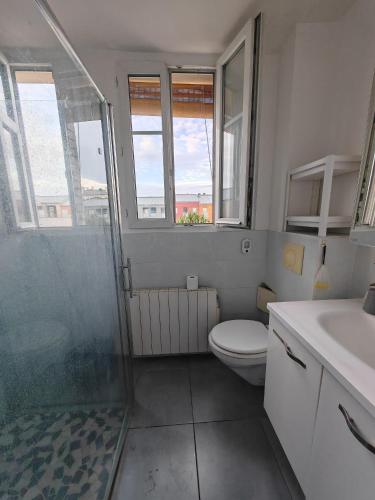 uma casa de banho com um chuveiro, um WC e um lavatório. em Sean em Issy-les-Moulineaux