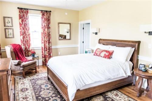 a bedroom with a bed and a chair and a window at Marriott Ranch Bed and Breakfast in Hume