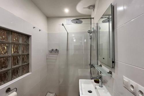 een witte badkamer met douche en wastafel bij La Sureña in Alhaurín el Grande