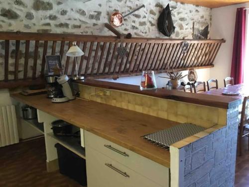 une cuisine avec un comptoir en bois dans une pièce dans l'établissement La Maison de Marie « Le Rocher », à Saint-Bonnet-en-Champsaur