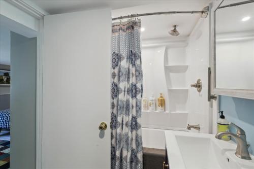 a bathroom with a shower curtain and a sink at Stowe Gallery Apartment in Stowe
