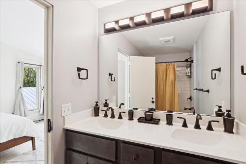ein Badezimmer mit einem Waschbecken und einem großen Spiegel in der Unterkunft The Mercer House in Stowe