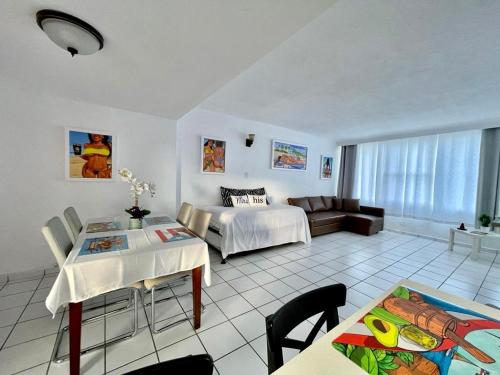 Condado Beachfront Tantra Apartment في سان خوان: غرفة معيشة مع سرير وأريكة