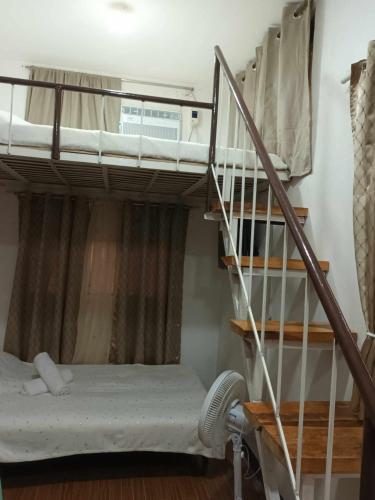 a bunk bed in a room with a ladder at FAST Wifi 400 Mbps Tiny House in Bacolod City in Bacolod