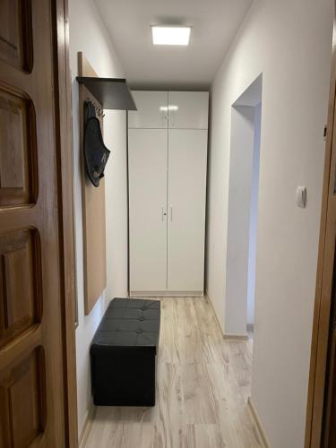 a room with a black ottoman and a closet at kawalerka PIECHOTY 5 os CENTRUM in Elblag