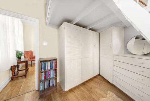 an attic room with a book shelf and a closet at Unique 1 BR flat btw Hammersmith & Fulham in London