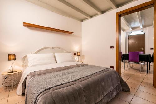 a bedroom with a large bed and a purple chair at Sweet House a Veronetta - A pochi metri dal Centro in Verona