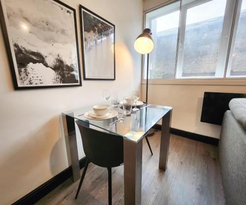 a dining room with a glass table and a couch at Remarkable 1Bed Apartment in Central Liverpool in Liverpool