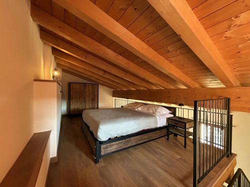 a bedroom with a bed and a wooden ceiling at La Volpe Rossa Rooms and Apartments in San Felice del Benaco