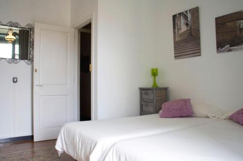 a white bedroom with a white bed and a window at Bed & Breakfast Bells Oficis in Girona