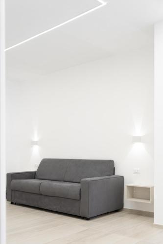 a grey couch in a white room with two lamps at Appartamento comfort-relax in Termoli
