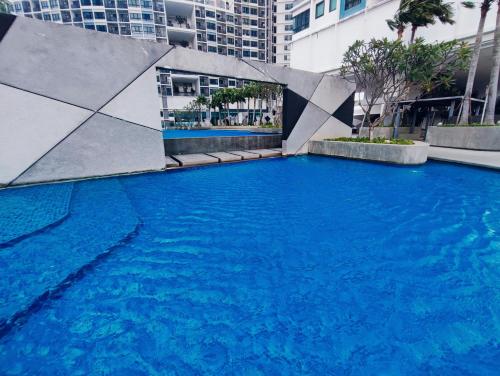 a large swimming pool with blue water in a city at I-City 2-Bedroom - Great Value Homestay in Shah Alam